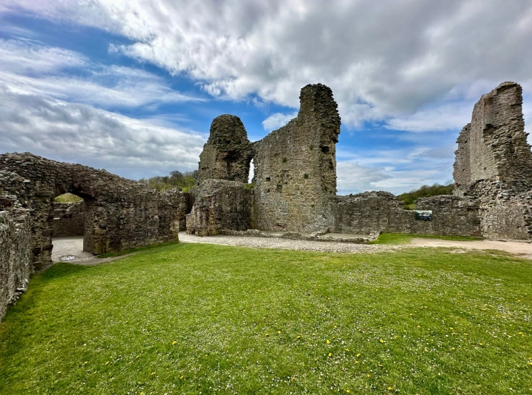 Adfeilion castell ac awyr las yn y cefndir.