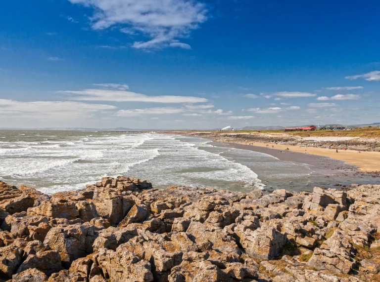 Golygfa o'r traeth gyda'r llanw'n dod i mewn