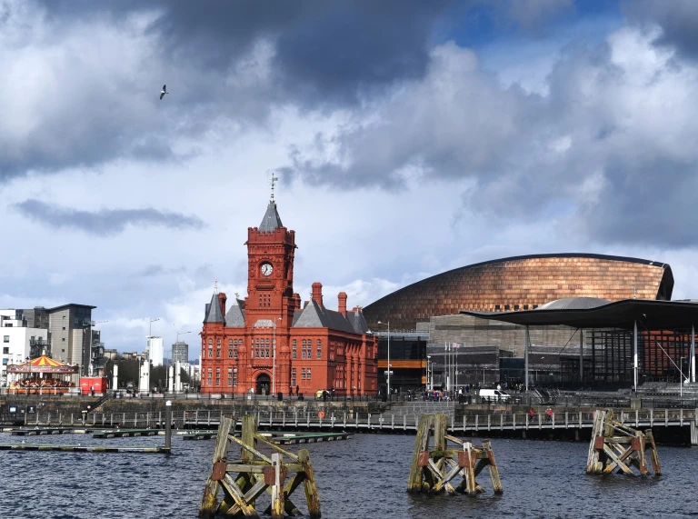 Historic red brick building with clock tower and copper coloured roof building.