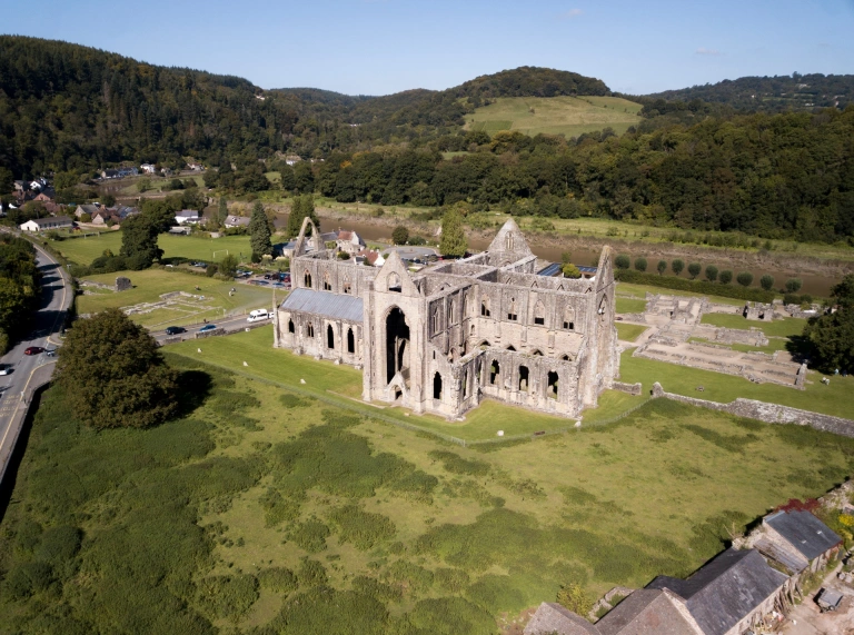 Golygfa o'r awyr o weddillion yr abaty gyda'r cefn gwlad o'i amgylch.