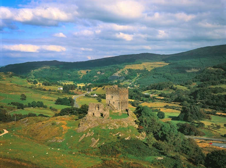 Llun o'r awyr o gastell ar fryn yng nghanol caeau gwyrdd.