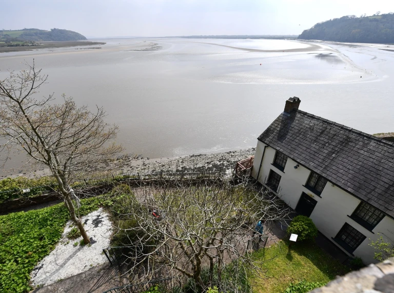 White house and garden overlooking the sea.