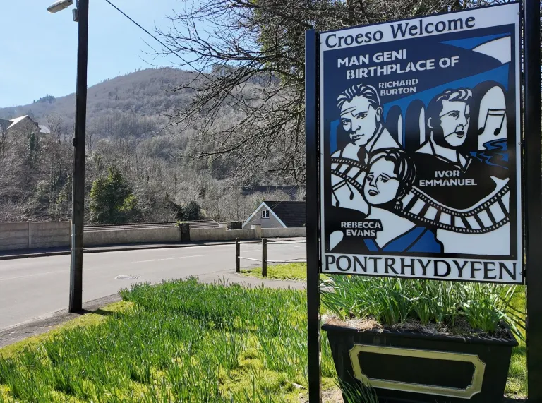 arwydd dwyieithog gyda lluniau o actorion a thraphont ynghyd â’r gair 'Pontrhydyfen'.