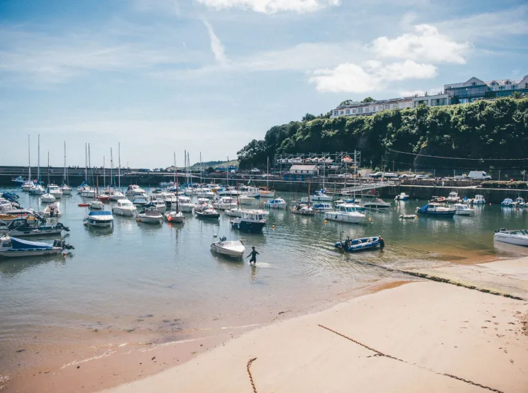 Cychod yn harbwr Saundersfoot ar ddiwrnod heulog.