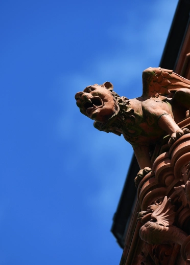 Cerflun o anifail ar ocher adeilad brics coch