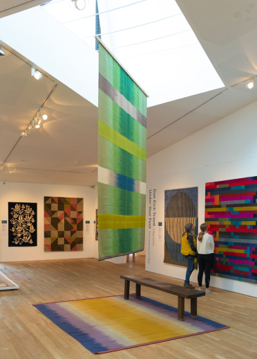 Two females looking at the wall and hanging displays at Ruthin Craft Centre.