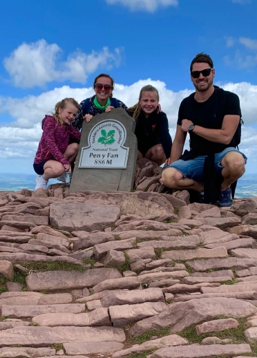 Teulu (Mam, Dad a dwy o ferched) ar ben Pen y Fan