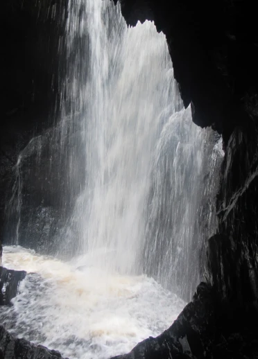 Rhaeadr yn ffrydio drwy ogof.