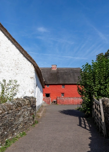 Tŷ fferm wedi ei beintio'n goch ar dir Amgueddfa Werin Cymru