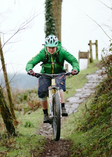 Beiciwr mynydd yn mynd i lawr llwybr.