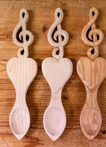 Tair llwy gariad gyda cherfiad nodyn cerddorol.