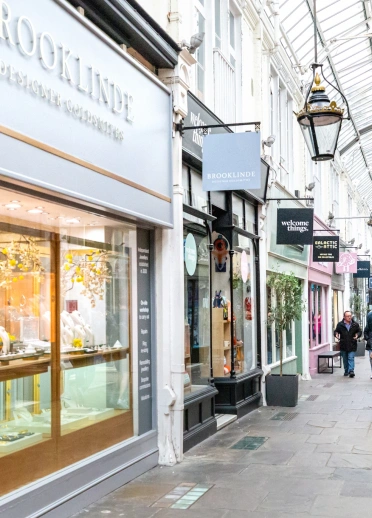 Arcêd siopa dan do gyda phobl yn cerdded heibio i siopau.