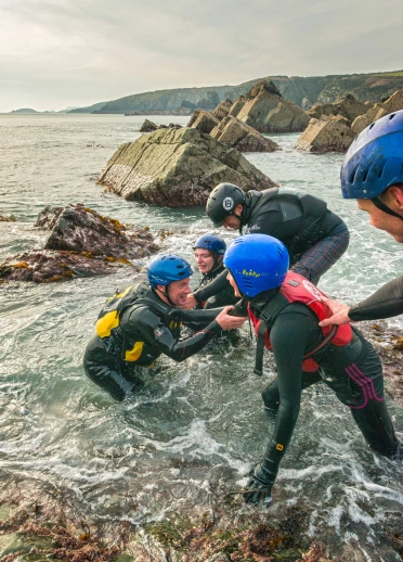 Group coasteering through rocks near St David's