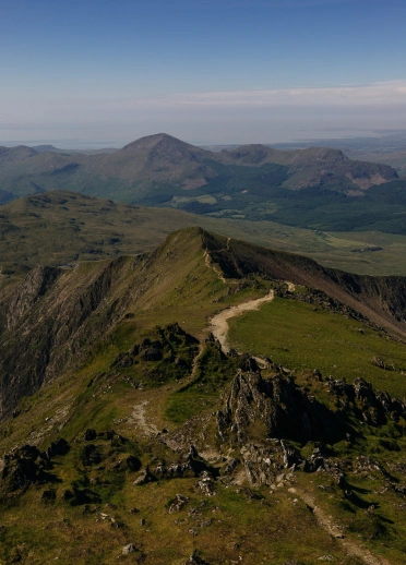 Edrych i lawr ar lwybr sy’n nadreddu i fyny mynydd.