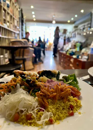 llun ago o bwyd ar blat efo cenfdir blurry o caffi deli.