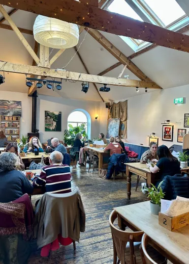 Caffi prysur efo bobl yn bwyta