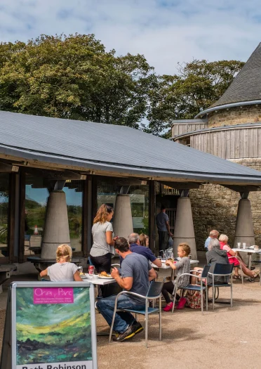 Pobl yn eistedd tu allan i Oriel y Parc, Tyddewi