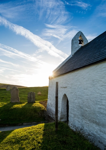 Llun heulog o ochr yr eglwys fechan wedi gwyngalchu