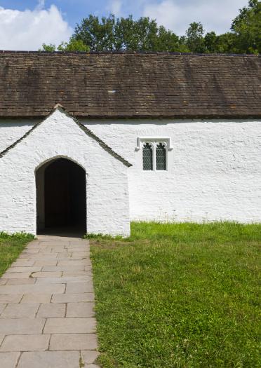 Outside of a white church with a path leading to the door