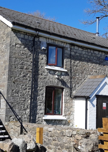 tu allan adeliad carreg gyda grisiau.
