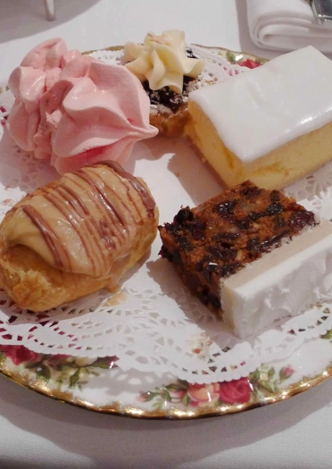 Platiaid o gacennau, gan gynnwys cacen ffrwythau a chacennau hufen.