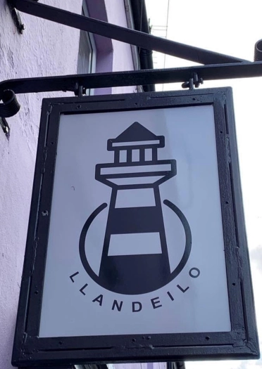 Arwydd siop gyda goleudy a’r gair Llandeilo