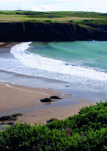 Y traeth gyda thon yn dod i mewn o'r môr