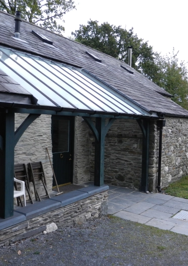 Mynedfa flaen allanol bwthyn carreg gyda mynediad cadair olwyn. 