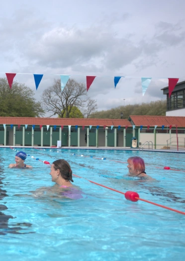 Menywod yn nofio mewn lido.