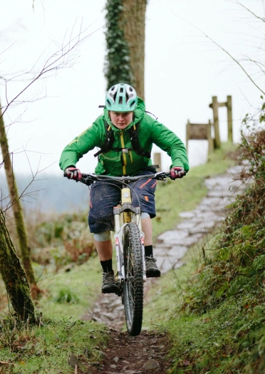 Beiciwr mynydd yn mynd i lawr llwybr.