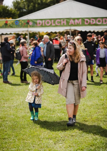 girl with umbrella and woman at festival.