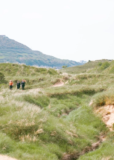 Tair menyw yn cerdded mewn gwarchodfa natur.
