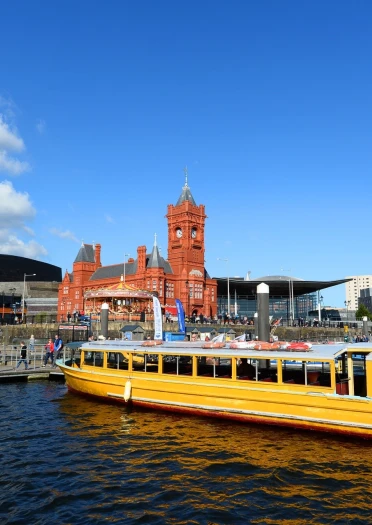 Tacsi Dŵr Bae Caerdydd gydag Adeilad y Pierhead a Chanolfan y Mileniwm yn y cefndir.