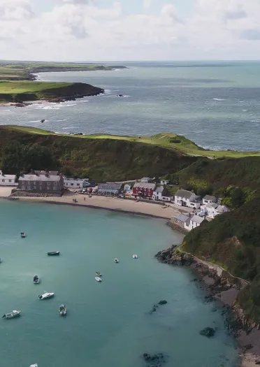 Cildraeth tawel gyda chaffi clyd yn rhoi golygfeydd hardd o’r môr