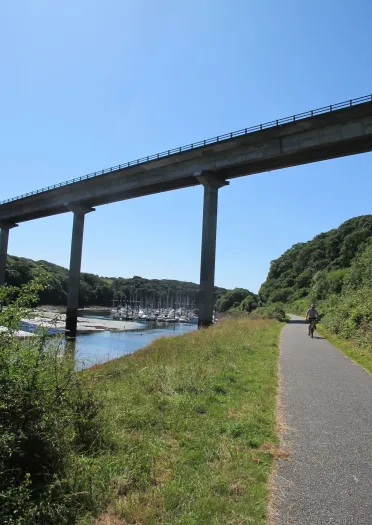 Llwybr beicio gyda phont a marina.