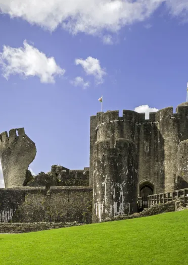 castell gyda thŵr cam ar ddiwrnod braf.