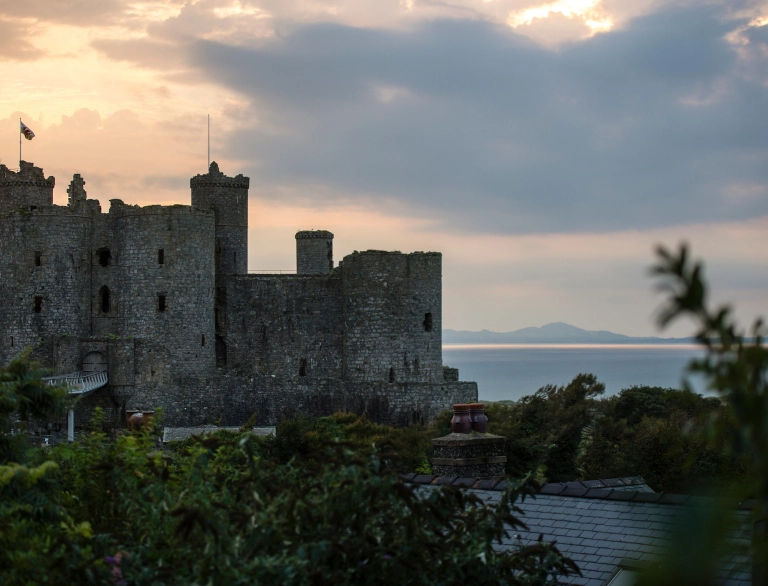 Llun o'r tu allan i'r castell wrth iddi nosi