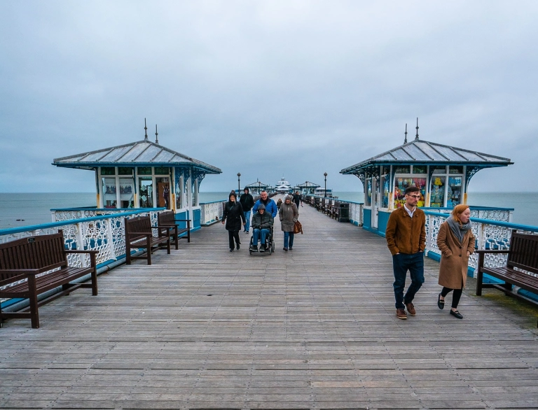 Golygfa ar hyd Pier Llandudno yn edrych allan i'r môr.