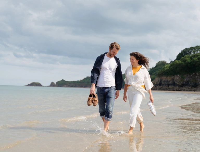 Cwpwl yn cerdded ar y traeth 