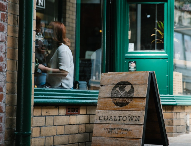 Y tu allan i Coaltown Coffi gydag arwydd pren