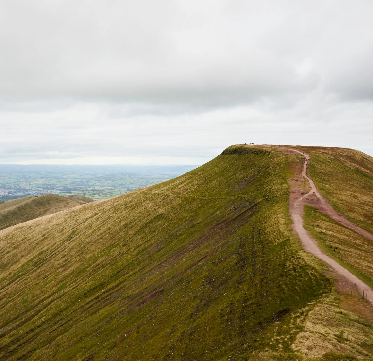 Copa mynydd Pen y Fan, gyda chopaon eraill yn y cefndir