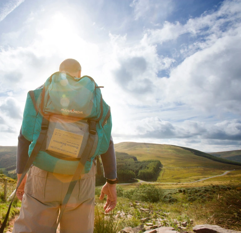 man with a backpack hiking through the Bannau Brycheiniog (Brecon Beacons).
