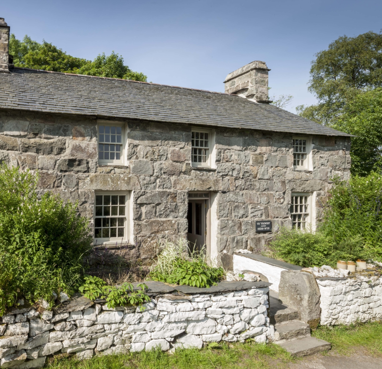 Llun o'r tu allan i hen ffermdy cerrig