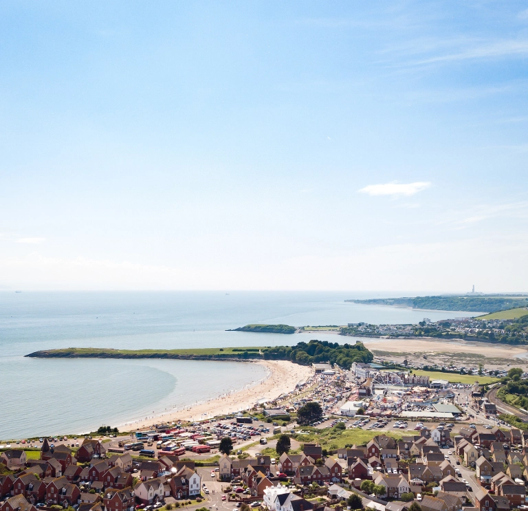 Llun o'r awyr o Ynys y Barri, yn cynnwys y traeth, y parc antur a thai