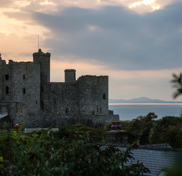 Llun o'r tu allan i'r castell wrth iddi nosi
