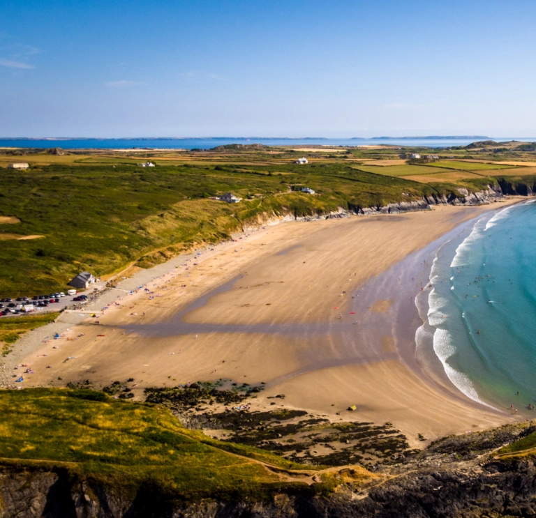 Traeth llydan, tywodlyd a welir oddi uchod.