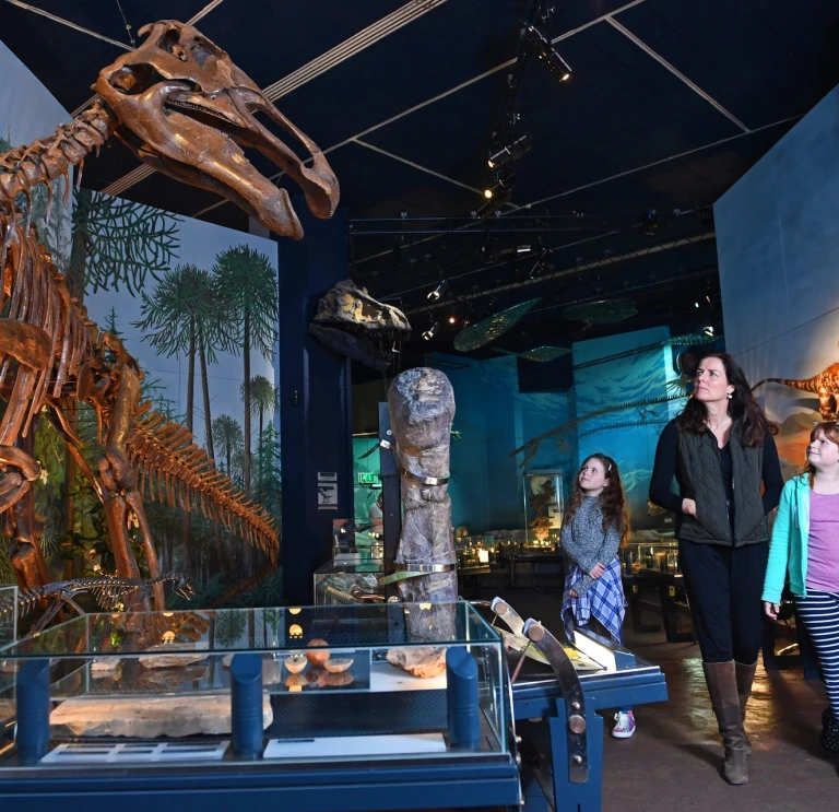 Mam a merch yn edrych ar arddangosfa deinosoriaid