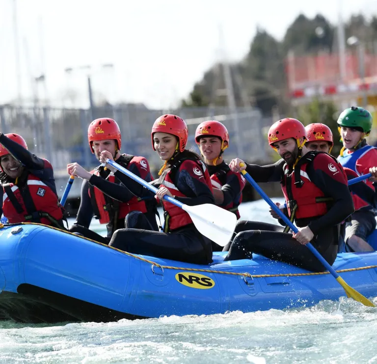 Pobl yn eistedd ar rafft las ar y dŵr