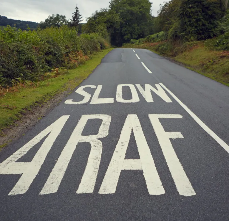 Darn o ffordd yr A470 gydag arwydd araf ar y ffordd. 