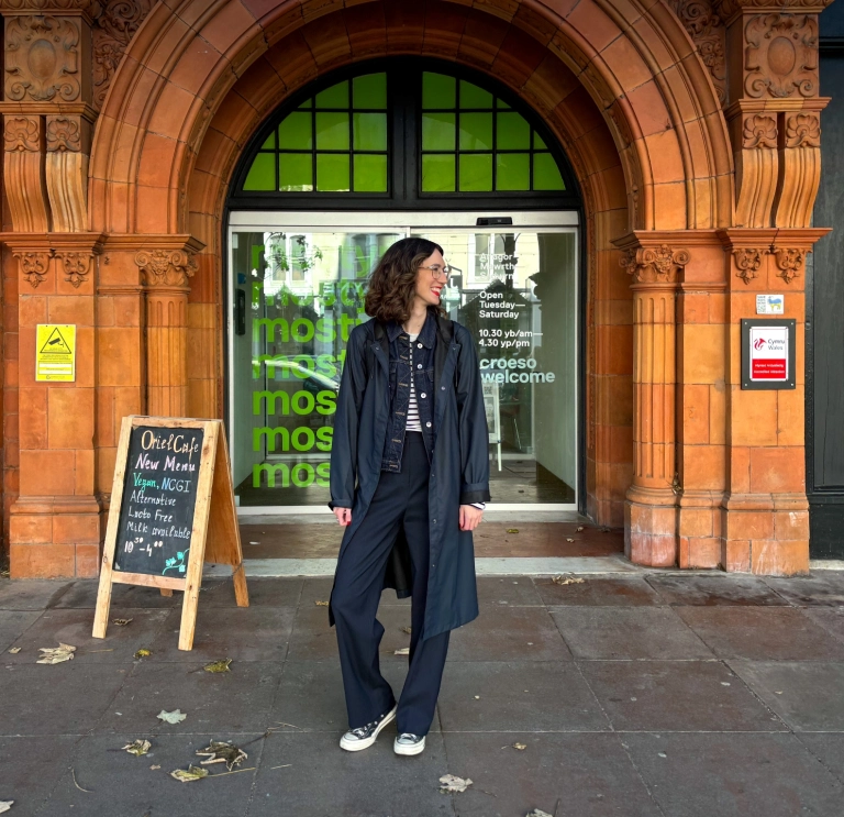 Menyw yn sefyll y tu allan i fynedfa'r oriel gelf sy'n cynnwys gwaith brics addurnedig.